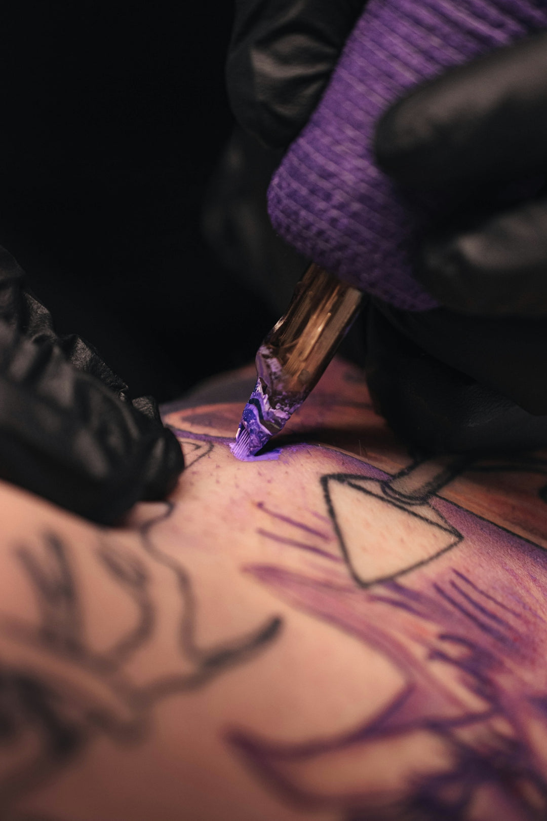 a person getting a tattoo done by a tattoo artist