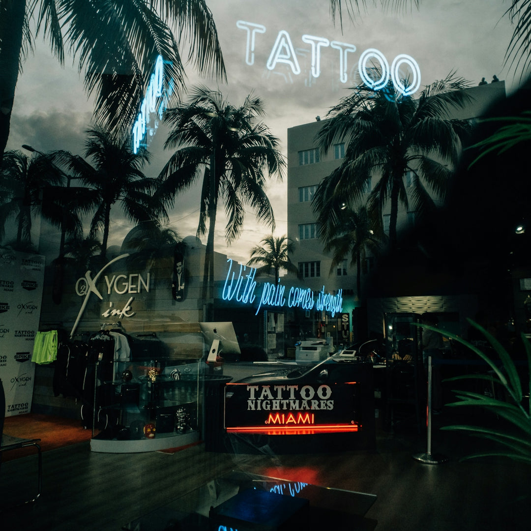 a tattoo shop with palm trees in the background