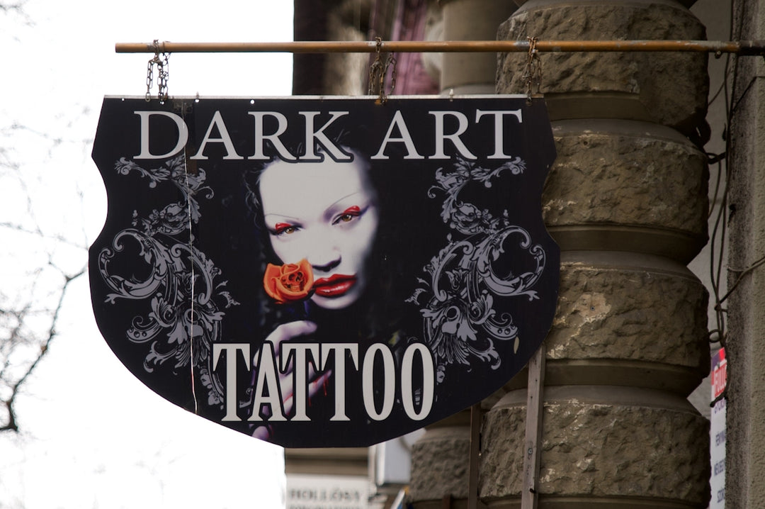 a sign on the side of a building that says dark art tattoo