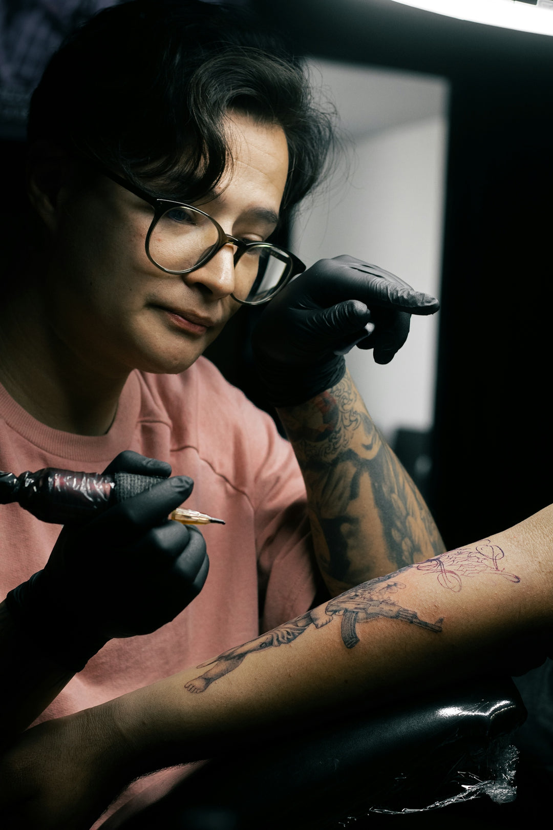 A tattoo artist is inking a design.