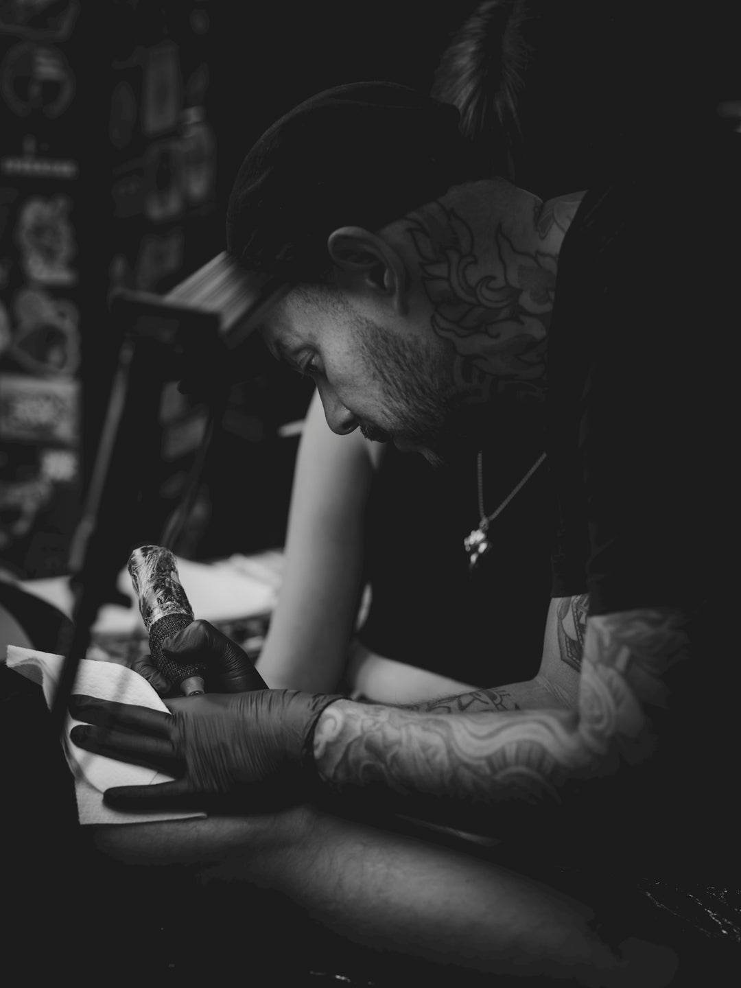 Tattoo artist working on a client's hand